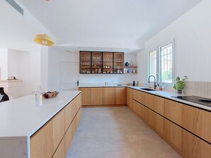 A modern kitchen with wooden cabinets, a white countertop, and a built-in shelf unit. - La Villa Nana by Interhome (Saint Cyr sur mer Les Lecques)