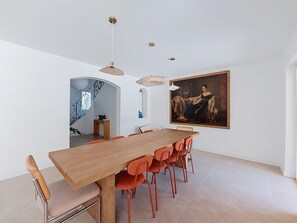 A modern dining area with a wooden table, orange chairs, and pendant lighting. - La Villa Nana by Interhome (Saint Cyr sur mer Les Lecques)