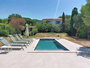 A rectangular swimming pool with a tiled deck, surrounded by lounge chairs and an umbrella. - La Villa Nana by Interhome (Saint Cyr sur mer Les Lecques)