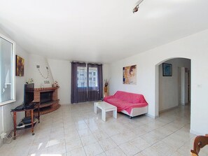 Ein Wohnzimmer mit Fernseher, Sofa und Kamin.