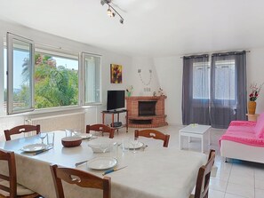 A dining area with a table set for four, a fireplace, and a television. - Le moulin by Interhome (La Ciotat)
