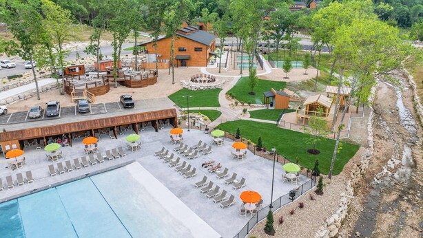 Et resort med swimmingpool, udendørs siddepladser og udsigt til de omkringliggende bakker.