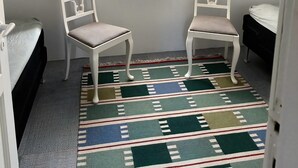 A room with two white chairs, a patterned rug, a framed picture of a rooster, and a framed picture with text. - Enjoy island life in a Sejerø holiday home (Sejerø)