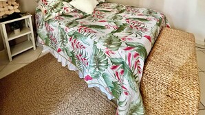 Ein Schlafzimmer mit Bett, Nachttischen, einem Spiegel und Wanddekorationen.