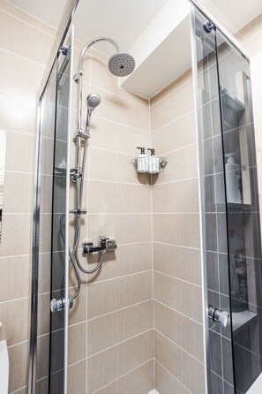 A glass-enclosed shower with a handheld showerhead and a wall-mounted faucet. - Prague Castle Oasis by Interhome (Praha/6)