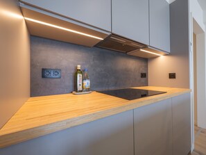 Una cocina moderna con encimera de madera, electrodomésticos integrados y salpicadero.