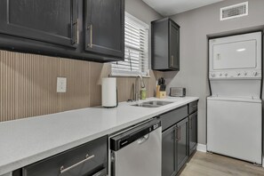 A compact kitchen with a dishwasher, a built-in oven, and a sink. - El Camino:Comfy King Beds-Walk to Campus/Northgate (Bryan)