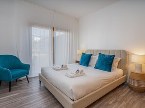 A hotel room with a bed, a chair, a lamp, and a window with curtains. - Marina retreat with lake view (Lagos)