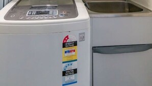 A laundry room with a front-loading washing machine and a sink. - City and Park View Close to Station 1 Car Space (Beaconsfield)