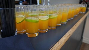 A row of glasses with a yellow beverage, possibly a cocktail, on a bar counter. - Hotel Manor - Datchet, Windsor (Slough)