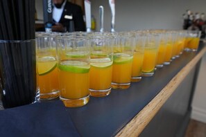 A row of glasses with a yellow beverage, possibly a cocktail, on a bar counter. - Hotel Manor - Datchet, Windsor (Slough)