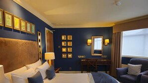 A hotel room with a large bed, bedside tables, a desk, a chair, and a window with curtains. - Hotel Manor - Datchet, Windsor (Slough)