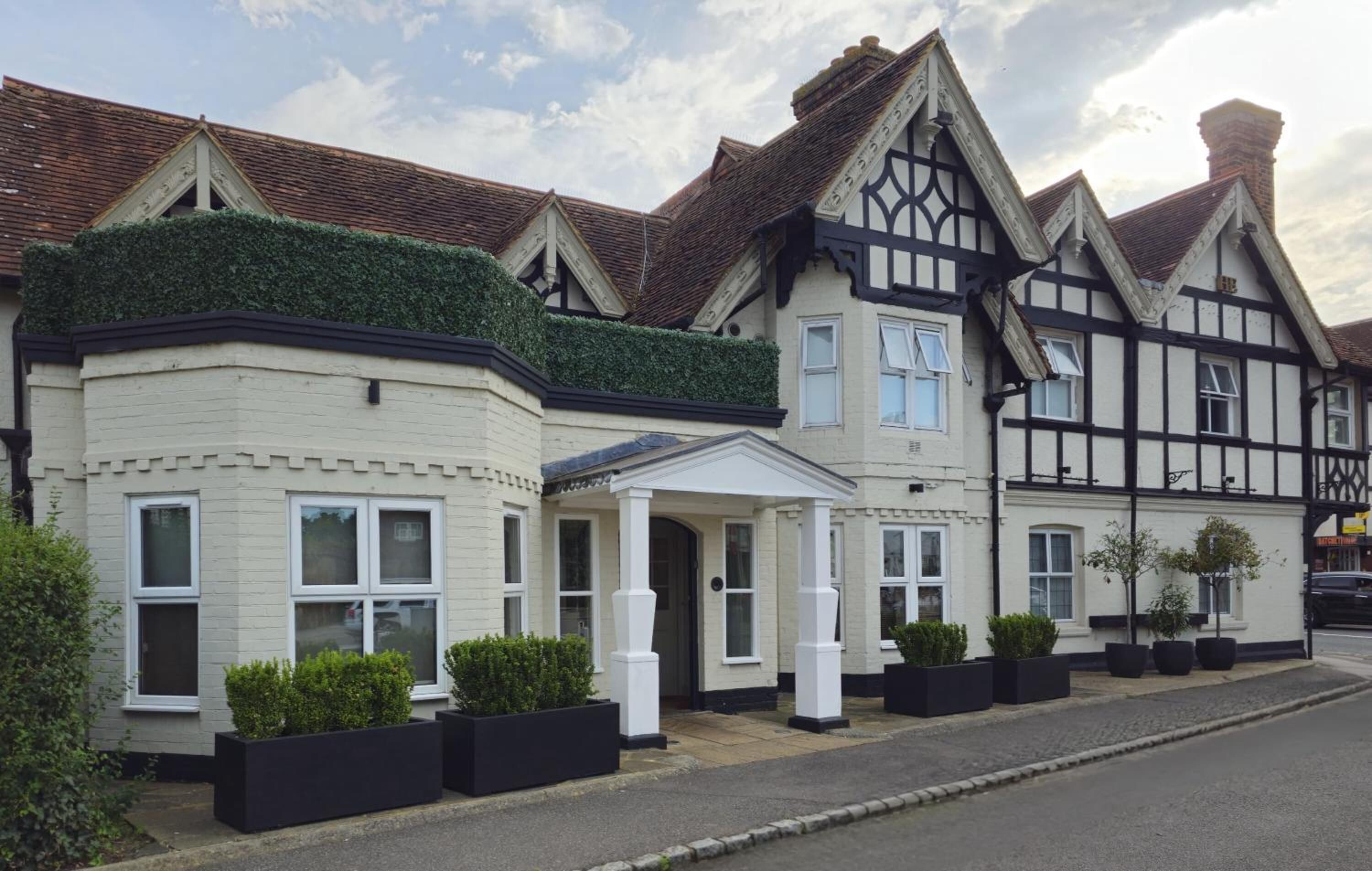 A row of traditional houses with distinct architectural styles, including a bay window and a gabled roof.