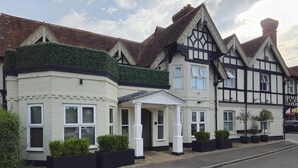 A row of traditional houses with distinct architectural styles, including a bay window and a gabled roof. - Hotel Manor - Datchet, Windsor (Slough)