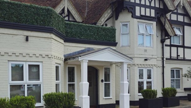 A traditional two-story house with a gabled roof, a front porch, and a hedge. - Hotel Manor - Datchet, Windsor (Slough)