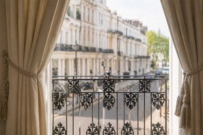 Ein Balkon mit schmiedeeisernen Geländern und Blick auf eine Häuserreihe.