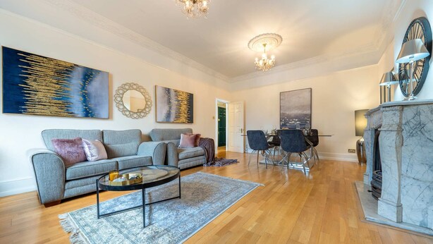 A spacious living room with a sofa, coffee table, and fireplace. - Deluxe 2 Bedroom Apartment In An Amazing Location (London)