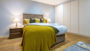 A bedroom with a bed, nightstands, and a wardrobe. - Sophisticated Splendor2-bedroom House in Mayfair (London)