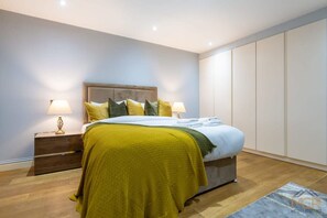 A bedroom with a bed, nightstands, and a wardrobe. - Sophisticated Splendor2-bedroom House in Mayfair (London)