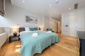 Ein geräumiges Schlafzimmer mit einem großen Bett, einem Bild an der Wand und einem Kleiderschrank.