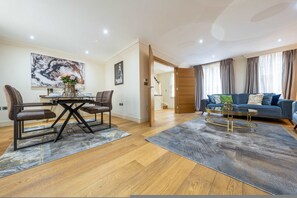 A modern living room with a dining table, sofa, and coffee table. - Exquisite 3-bedroom House in Mayfair (London)