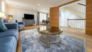 A modern living room with a sofa, a coffee table, and a flat-screen TV. - Exquisite 3-bedroom House in Mayfair (London)