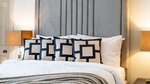 A neatly made bed with a headboard, a bedside lamp, and a door. - Superior 2 Bedroom Apartment in Mayfair (London)