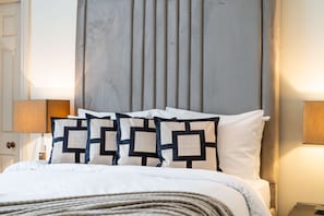A neatly made bed with a headboard, a bedside lamp, and a door. - Superior 2 Bedroom Apartment in Mayfair (London)