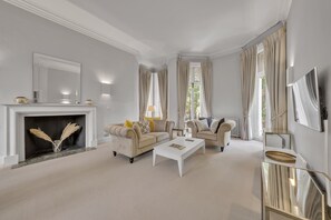Ein Wohnzimmer mit Kamin, zwei Sofas, einem Couchtisch und einem Fernseher.