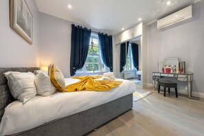 Ein Schlafzimmer mit einem Bett, einem Schreibtisch und einem fensterbepflanzten Fenster.