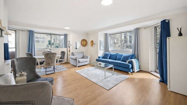 Un salon moderne comprenant un canapé, des fauteuils, une table basse et un coin repas.