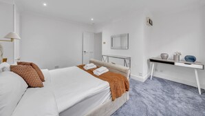 Una camera d'albergo con un letto, una scrivania, uno specchio e una porta.