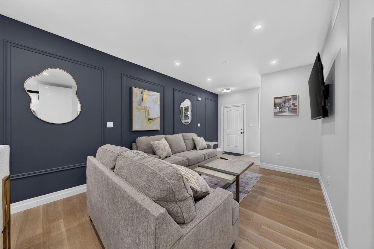A modern living room with two sofas, a coffee table, and artwork on the walls.
