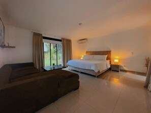 A bedroom with a bed, bedside table, and a window with curtains. - Private Poblado Tropical Estate 10BR Pool 18Person Jacuzzi Walk to GoldenMile AC (Medellín)