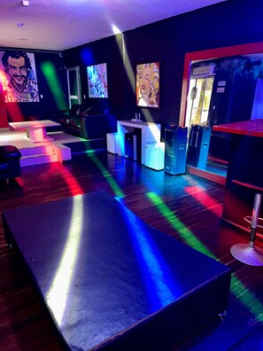 A modern lounge area with a bar, seating, and artwork on the walls. - Private Poblado Tropical Estate 10BR Pool 18Person Jacuzzi Walk to GoldenMile AC (Medellín)