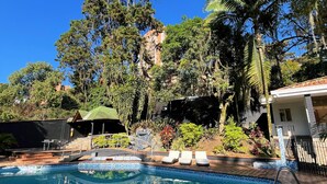 Una piscina con bordes de azulejos, rodeada por un patio a cuadros.