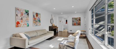 A modern living room with a sofa, a coffee table, and artwork on the walls.