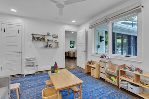 A room with a wooden table, chairs, a bookshelf, and a window with blinds. - Stylish home in Historic Forest Park perfect for a family retreat (Birmingham)