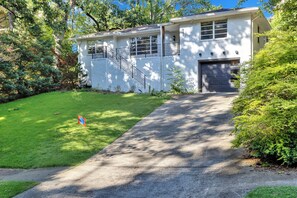 A two-story house with a front entrance, a visible staircase, and a garage. - Stylish home in Historic Forest Park perfect for a family retreat (Birmingham)