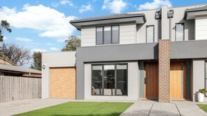 A modern two-story house with a garage, large windows, and a well-maintained lawn. - The Cowes Retreat by Ready Set Stay (Cowes)