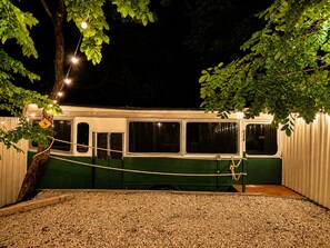 A stationary train car with windows, a rope tied across the middle, and a gravel ground. - 2-bedroom converted Bus in Guanacaste Liberia near airport and beaches (Provincia de Guanacaste)