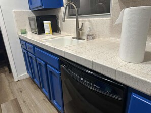 A kitchen with a dishwasher, a sink, and a countertop.