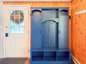 A room with a white door, a window with a view, and a blue cabinet with shelves. - Lakefront Escape - Dock, Beach, Grill & Hot Tub (Milton)