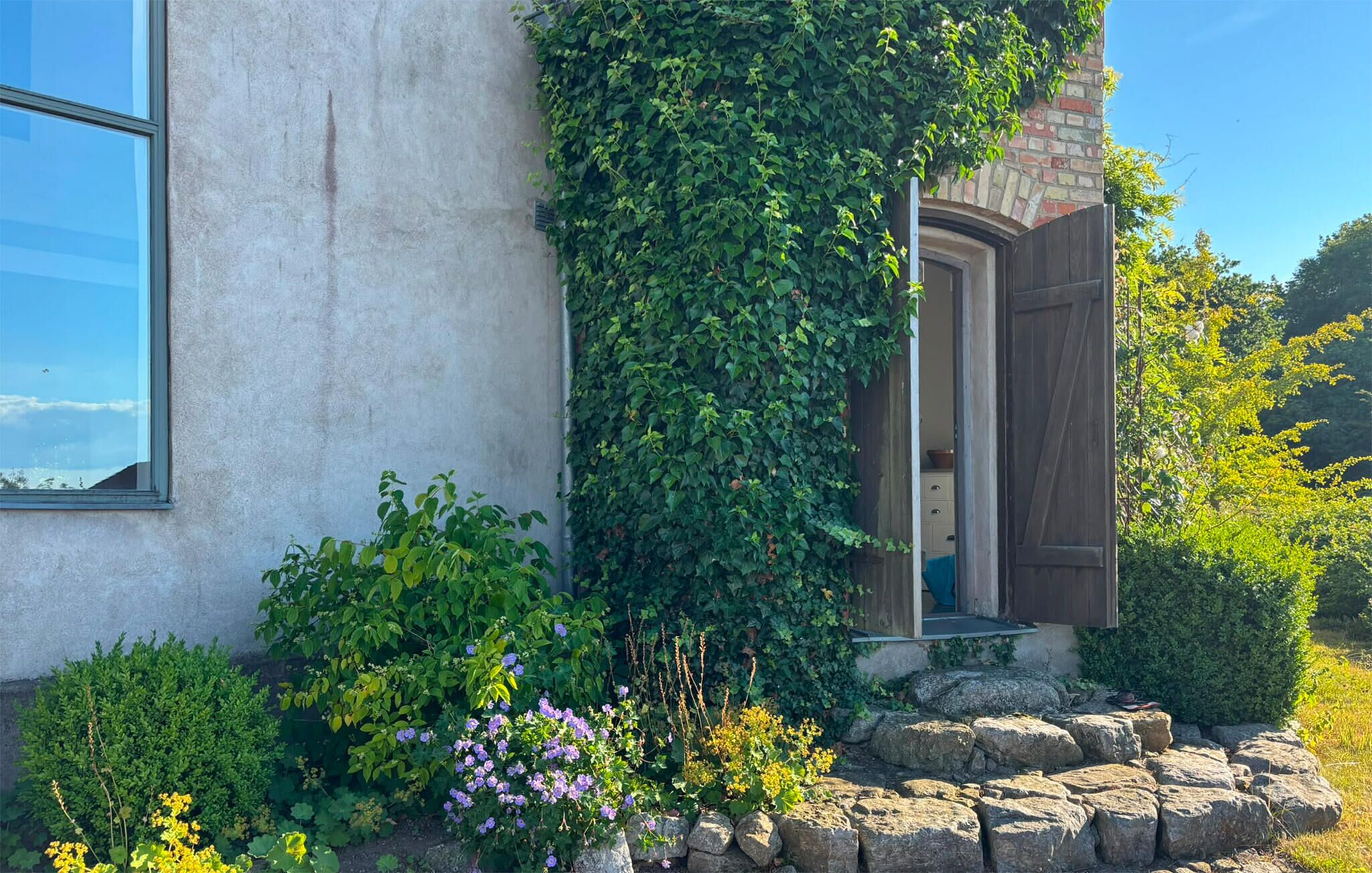 Una casa con cimientos de piedra, una ventana y una puerta.