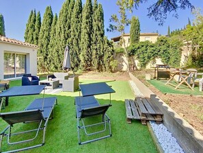 Een terras met tuinmeubilair, een barbecue en een pooltafel.