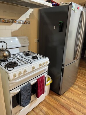 A kitchen with a gas stove, oven, and a stainless steel refrigerator. - THE GREENERY Castlemaine- whole house comfort + extensive gardens -dog friendly (Castlemaine)