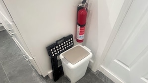 A bathroom with a white toilet, a black mat, a fire extinguisher, and a ladder. - Prime location Studio,King Bed,Filtered shower,Near Airport Las Vegas Blvd (Las Vegas)
