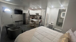 A compact hotel room with a bed, a small kitchenette, a seating area, and a bathroom. - Prime location Studio,King Bed,Filtered shower,Near Airport Las Vegas Blvd (Las Vegas)
