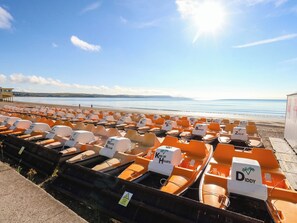Reihen von Wasserfahrzeugen unterschiedlicher Marken, ein Strand im Hintergrund und ein klarer Himmel.