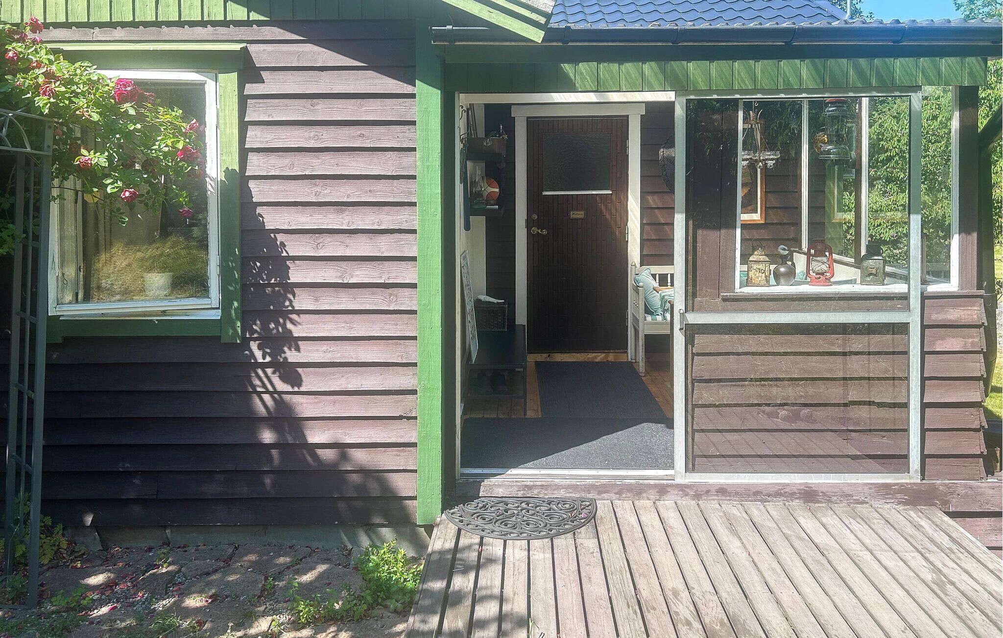 A wooden building with a door, a window, and a small porch area.